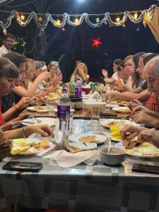 コーラムにあるAshtamudiVillasのテーブルに座って食事を楽しむ人々のグループ