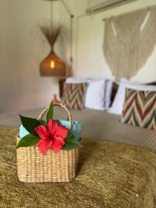 een mand met een rode bloem bovenop een bed bij Villa Turquesa - Home in Morro de São Paulo