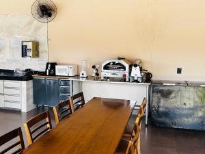een keuken met een houten tafel en een keuken met een aanrecht bij Chácara mana in Anápolis