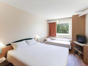 Un dormitorio con una cama blanca grande y una ventana en Ibis Murcia, en Murcia 54 fotos más