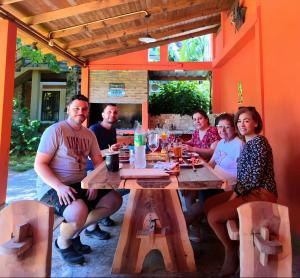 um grupo de pessoas sentadas numa mesa de madeira em Hospedaje Los Vencejos em Porto Iguaçu mais 40 fotografias
