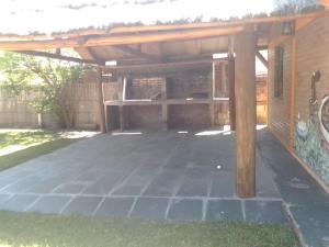 eine große Terrasse mit einer hölzernen Pergola in der Unterkunft Cabañas Ojo de Agua in Trapiche