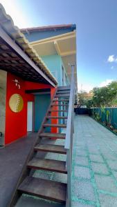 a staircase leading to a house with a red wall at Sol da pipa - suítes in Pipa