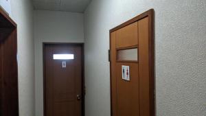 a hallway with a wooden door and a door at Red Gate Lodge in Kijimadaira