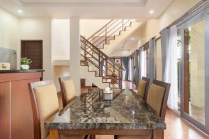 a dining room with a marble table and chairs at Singaraja Sea View Villa in Singaraja