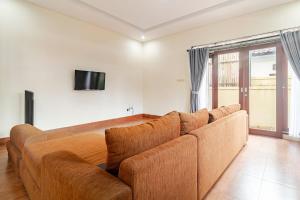 een bruine bank in een woonkamer met een tv bij Singaraja Sea View Villa in Singaraja