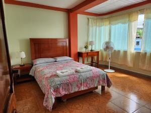 プヨにあるDepartamento Amazonia Ecuadorのベッドルーム1室(ベッド1台、ファン、窓付)
