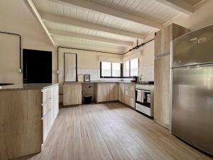 una grande cucina con pavimenti in legno e frigorifero in acciaio inox di Casa Cibelli a Rufino