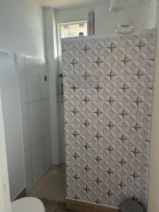 ein Badezimmer mit Dusche und weiß gefliester Wand in der Unterkunft CasaRiva in Biguaçu