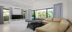 Nua Tone Pool Villa I Mountain View I Bangtao Beach في Ban Thalat Choeng Thale: غرفة معيشة مع أريكة وتلفزيون