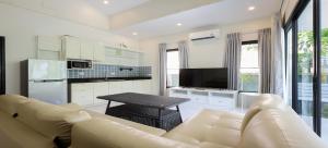 Nua Tone Pool Villa I Mountain View I Bangtao Beach في Ban Thalat Choeng Thale: غرفة معيشة بيضاء مع أريكة وطاولة