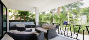Nua Tone Pool Villa I Mountain View I Bangtao Beach في Ban Thalat Choeng Thale: شرفة مع كرسيين وأريكة على شرفة