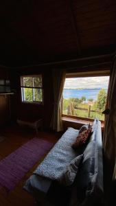 Cabaña Arte Patagonia في بويوهو: سرير في غرفة ذات نافذة كبيرة