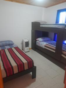 a bedroom with two bunk beds and an air conditioner at Cabañas San Benito in Los Antiguos