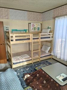 una habitación con dos literas y una mesa en Southern Alps Kaikomagatake Foot of the Kaikoma, en Hokuto