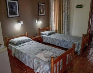 um quarto de hotel com duas camas em um quarto em Hospedaje Los Vencejos em Porto Iguaçu