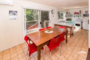 Una cocina y un comedor con una mesa de madera y sillas rojas. en Sandy Escape, en Sandy Point