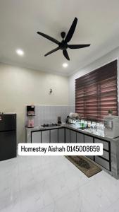 eine Küche mit Deckenventilator in einem Zimmer in der Unterkunft Homestay Aishah in Kota Bharu