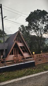 a house with a black roof and a fence at Cloud Peak in Vagamon