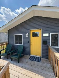 ein blaues Haus mit einer gelben Tür auf einem Deck in der Unterkunft Renovated 2BR Home Near Notre Dame & Eddy St in South Bend