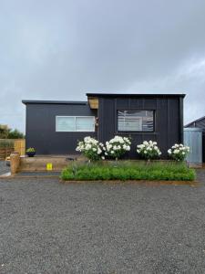 una casa negra con flores delante en Haven On Tau, en Ohakune