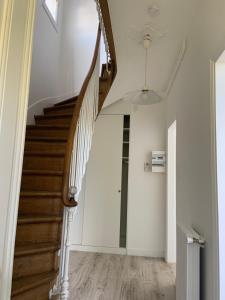 een trap in een huis met witte muren en houten vloeren bij Petite Maison in Châtenay-Malabry