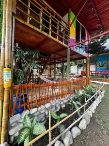 a building with a fence next to some plants at Cabañas Casa Luna in Rivera
