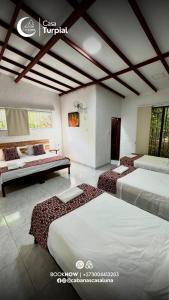 a room with three beds and a bench in it at Cabañas Casa Luna in Rivera