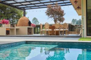 a swimming pool with chairs and a house at La Malenita casa en Amanalco in Amanalco de Becerra