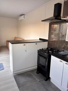 a kitchen with a black stove and white cabinets at Tres de Mayo in San Luis