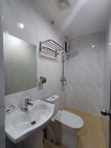 um banheiro branco com uma pia e um vaso sanitário em Asia Jem Hotel - Bacolod City em Bacolod