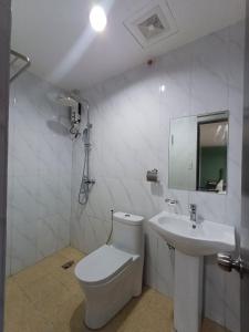 um banheiro branco com vaso sanitário e pia em Asia Jem Hotel - Bacolod City em Bacolod