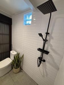 ein Badezimmer mit Toilette und Licht an der Wand in der Unterkunft Tendan Residence Hotel in Legian