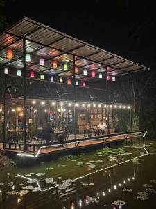a building with lights on the water at night at เป่าฟู่เฮ้าส์ Bao Fu's House in Chumphon +12 photos