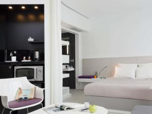 a hotel room with a bed and a table and chairs at Novotel Suites Malaga Centro in Málaga