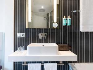 a bathroom with a white sink and a mirror at Novotel Suites Malaga Centro in Málaga +78 photos
