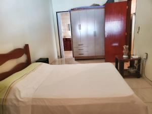 een slaapkamer met een wit bed en een kast bij Casa da Vila in Saquarema +5 foto's
