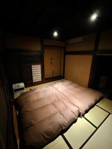 un grande letto nel mezzo di una stanza di うご八かやぶ㐂 a Narazaki