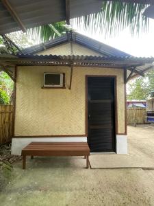 a bench in front of a building with a door at Hondelz Budget Homestay in Busuanga