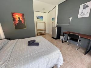 ein Schlafzimmer mit einem Bett und einem Schreibtisch und einem Schreibtisch in der Unterkunft Ban Supattra in Ban Khlong Mat