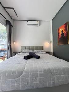 Ein Hut liegt auf einem Bett in einem Schlafzimmer in der Unterkunft Ban Supattra in Ban Khlong Mat