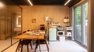 a kitchen with a wooden table and a refrigerator at gwangju chez pompom dokchae poolvilla in Gwangju