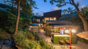 a house in the middle of a forest at night at gwangju chez pompom dokchae poolvilla in Gwangju