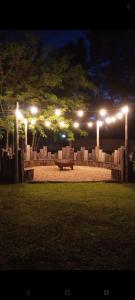 a bench in a park at night with lights at Casa Quinta in Mercedes