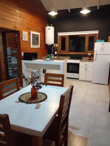 a kitchen with a white table and a white refrigerator at Casa Quinta in Mercedes