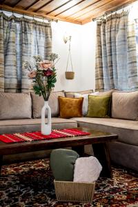 a living room with a couch and a table with a vase of flowers at Slona, Heritage Home in Old Town Plovdiv in Plovdiv