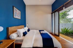 een slaapkamer met een bed en een blauwe muur bij Momo Villa Bandung in Bandung +41 foto's