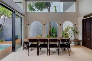 een eetkamer met een houten tafel en zwarte stoelen bij Momo Villa Bandung in Bandung
