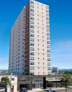 a large white building with a lot of windows at Depto Cómodo y Equipado en el Centro de Chillan con Estacionamiento in Chillán