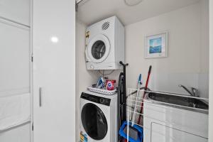 a washing machine in a kitchen next to a sink at Stylish 1-Bed Unit with Secure Parking in Braddon